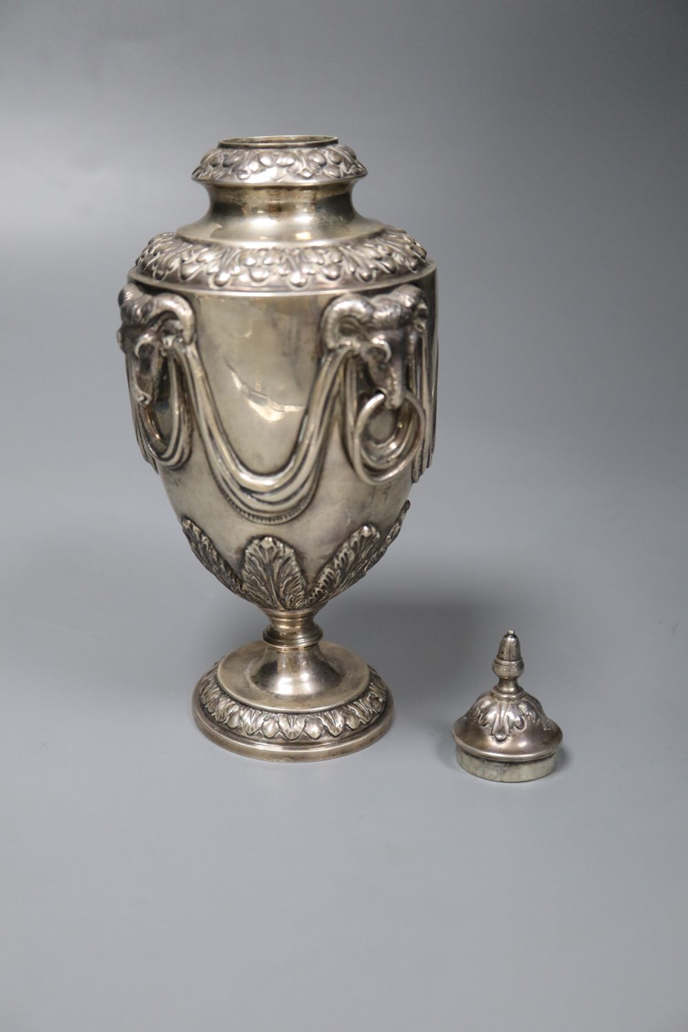 A George V silver vase and cover, with rams head and swag decoration and two ring handles, William Hutton & Sons, Sheffield, 1910,